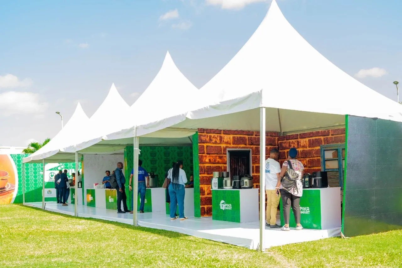 White tents at the Pika Smart exhibition, with visitors at the green display counters